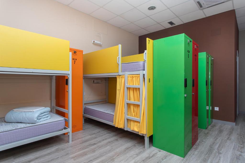 Cette chambre comprend 4 lits superposés et des couleurs différentes. dans l'établissement Albergue Hostel Llanes, à Llanes