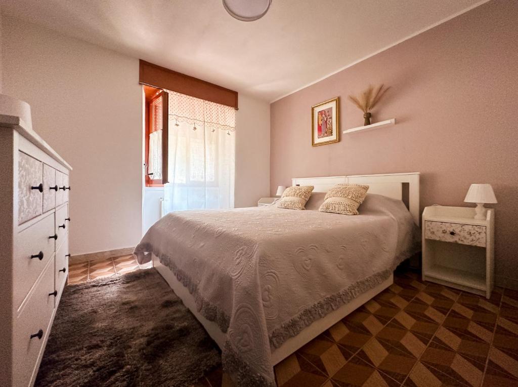 a bedroom with a bed and a dresser and a window at La Casetta di Giorgia in Fenis