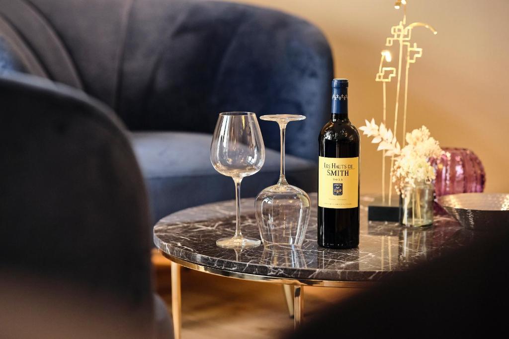 a bottle of wine and two glasses on a table at Maison Heym Bordeaux in Bordeaux