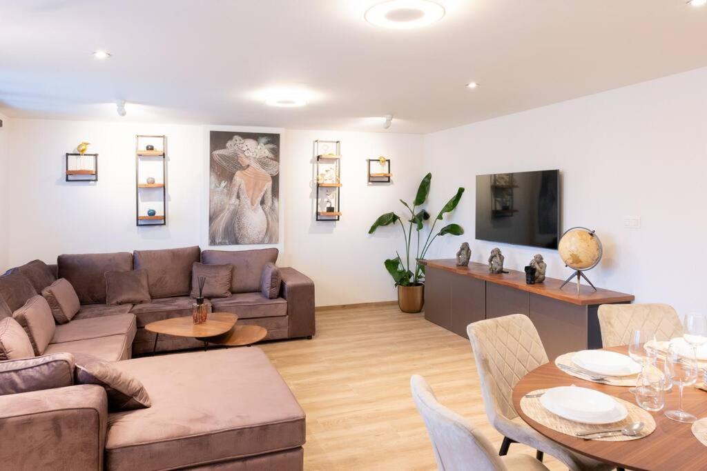 ein Wohnzimmer mit einem Sofa und einem Tisch in der Unterkunft Stijlvol appartement met jacuzzi & sauna in Herk-de-Stad