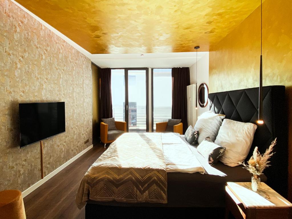 Exklusives Leipzig City Apartment Sunrise في لايبزيغ: غرفه فندقيه سرير وتلفزيون