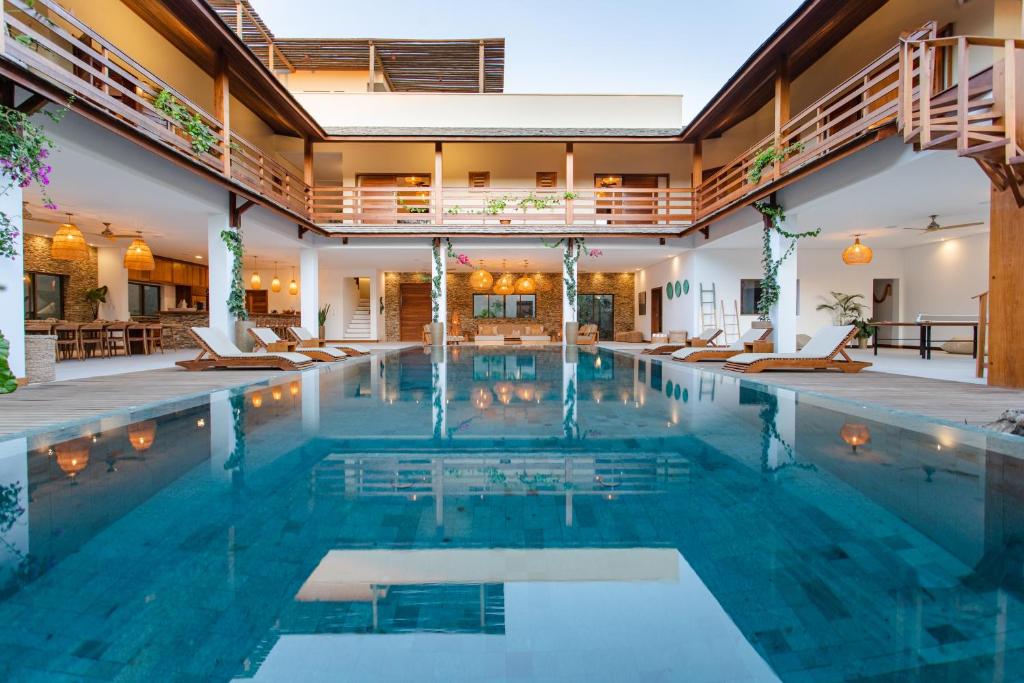 a swimming pool with chairs in a building at Aldeia Jericoacoara - Suites Privativas in Jericoacoara