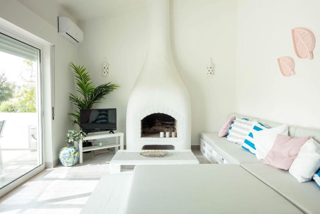 sala de estar blanca con sofá y chimenea en A Casa da Porta Azul, en Porches