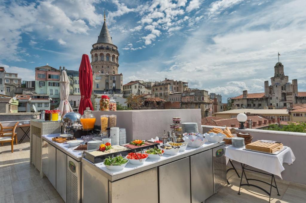 a breakfast buffet on a balcony with a view of the city at Galatower Hotel in Istanbul