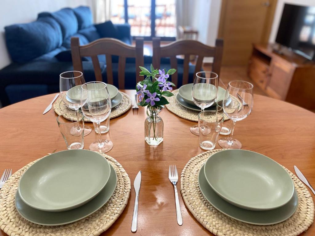 een houten tafel met borden en wijnglazen erop bij Mirador del Tiétar in Mijares