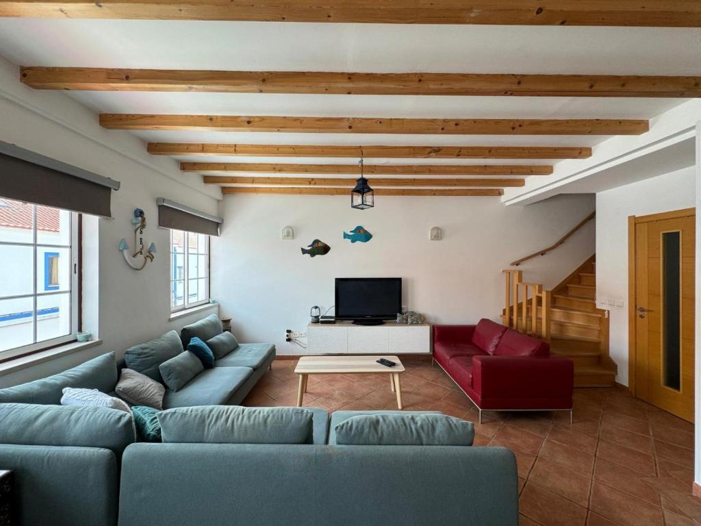 a living room with a couch and a tv at Porto Covo / Costa Alentejana in Porto Covo