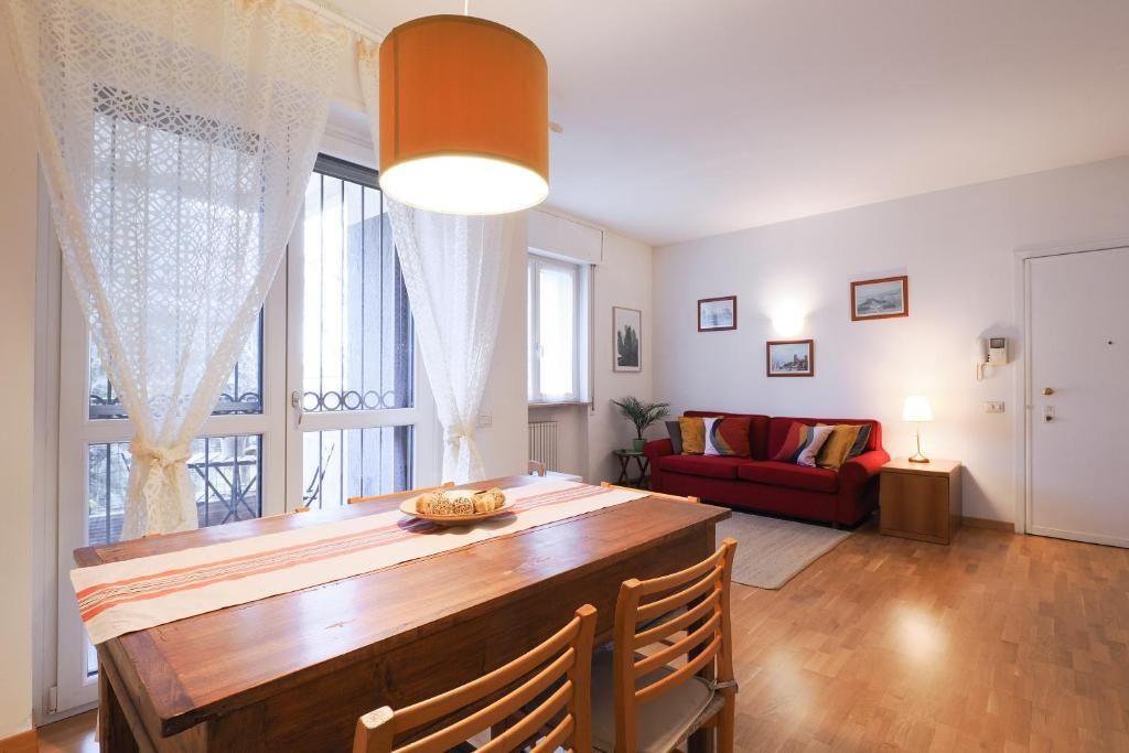 sala de estar con mesa y sofá rojo en PrimoPiano - Buccinasco en Buccinasco