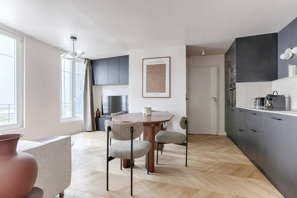 une cuisine avec une table et des chaises dans une pièce dans l'établissement MyKeypers - Luxury & Design Flat 1BR/4P- Bastille, à Paris