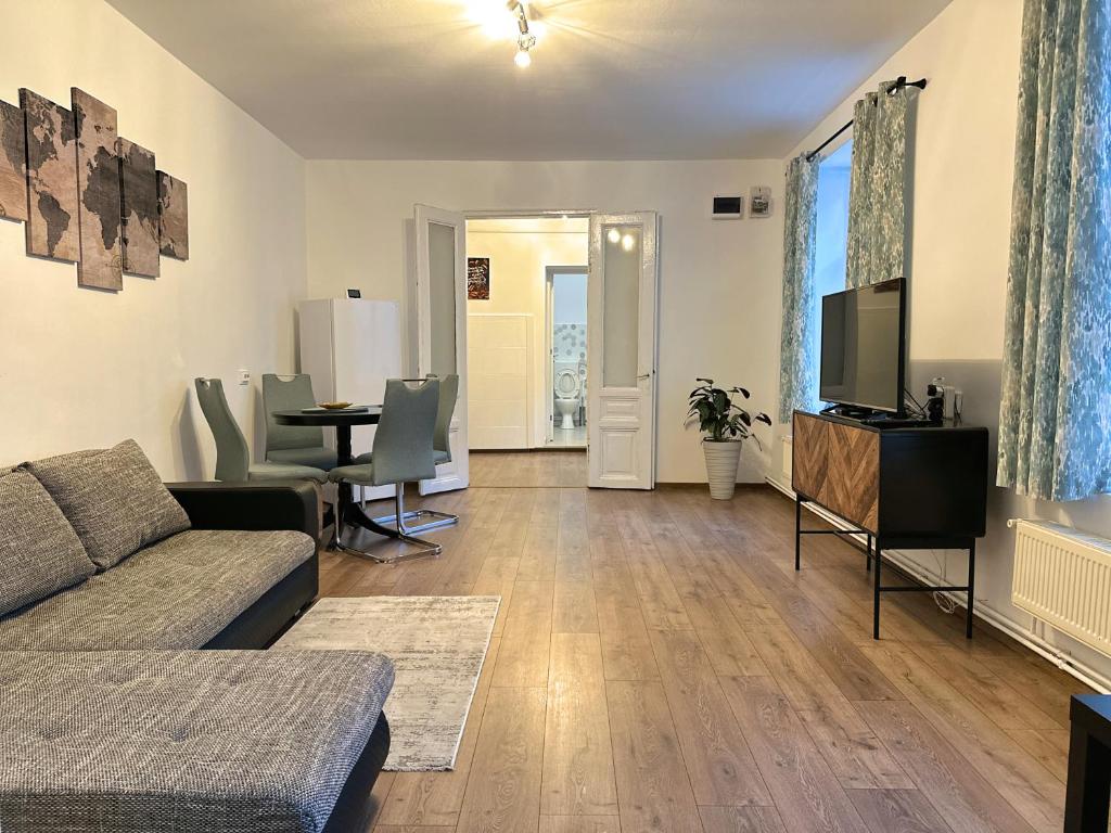 ein Wohnzimmer mit einem Sofa, einem TV und einem Tisch in der Unterkunft Take a Break Residence in Braşov