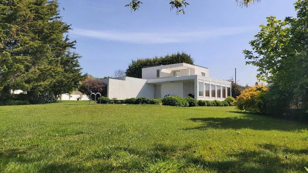 ein weißes Haus auf einem Feld mit einem Rasenplatz in der Unterkunft Casa de Gião in Gião