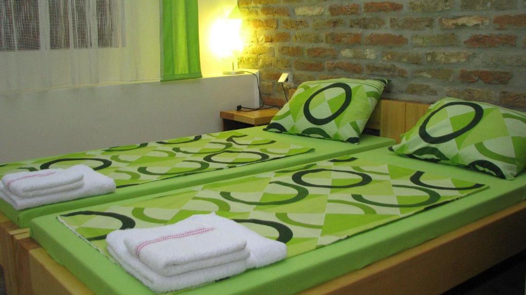 Una cama con toallas verdes y blancas. en Santa Maria Apartment, en Donji Kovilj