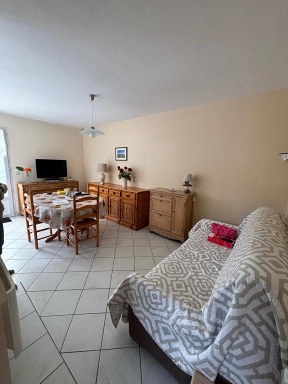 1 dormitorio con 1 cama y comedor con mesa en Maison 4 personnes face mer, en La Brée-les-Bains