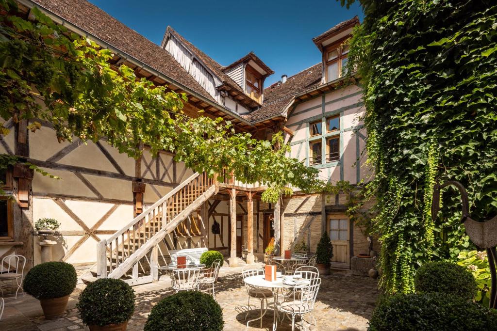 Casa con patio con mesas y sillas en Le Champ des Oiseaux & Spa, en Troyes