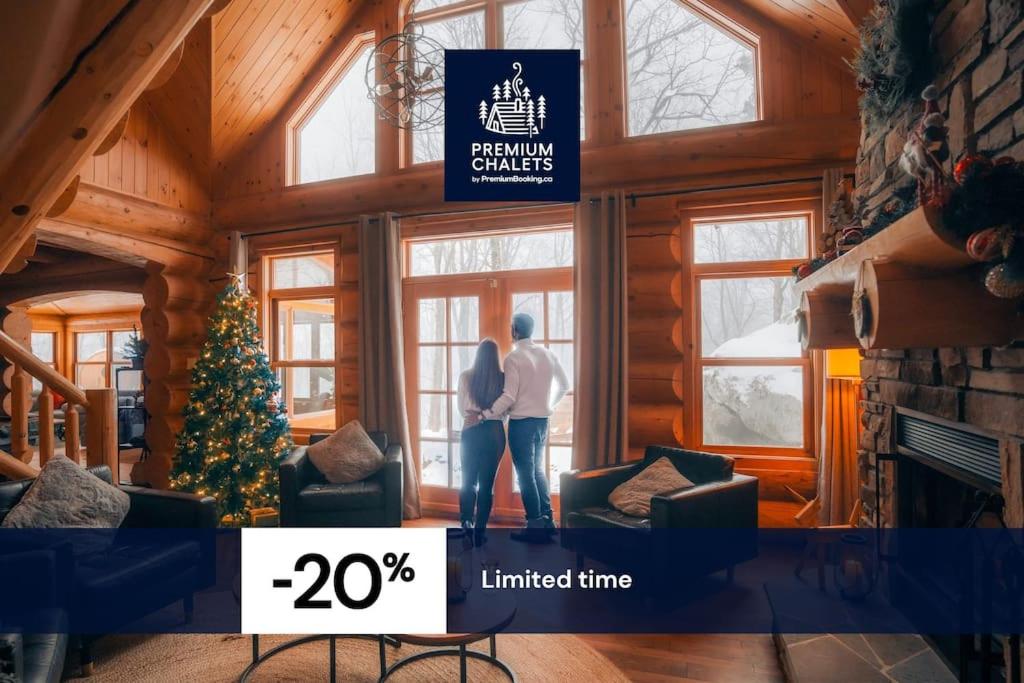 a couple standing in a living room with a christmas tree at Private Hot Tub Sauna Ski Indoor Pool Nyctale in Mille-Isles