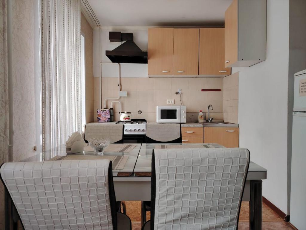 uma cozinha com mesa e cadeiras num quarto em Апартамент в центре города em Oral