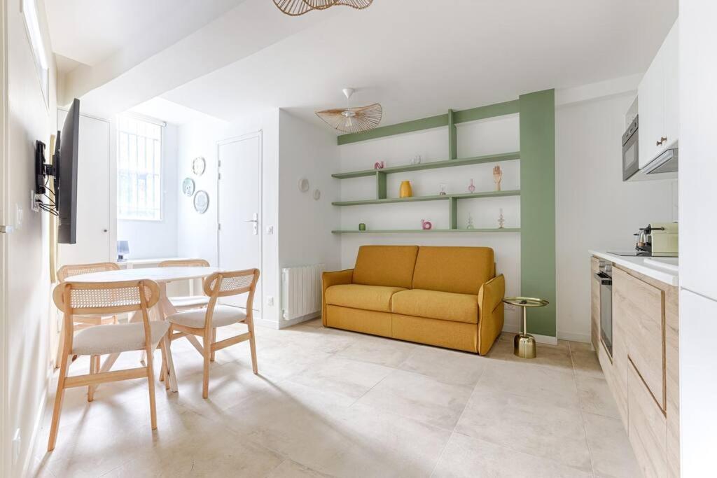 un salon avec un canapé jaune et une table dans l'établissement MyKeypers - Chic & Cozy Flat 4P - République, à Paris