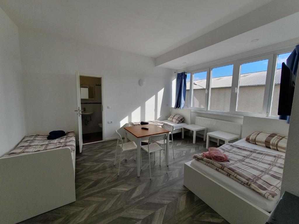 Habitación con 2 camas y mesa. en Akdeniz Pension, en Ludwigsfelde
