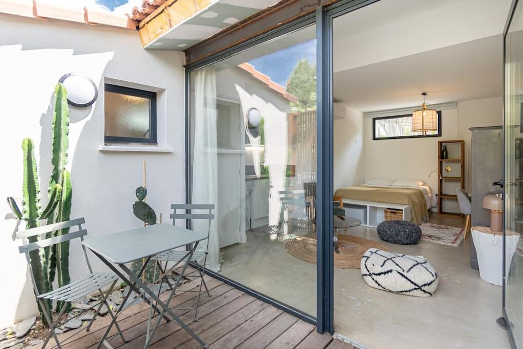 een kamer met een glazen schuifdeur en een tafel bij Le LilaRosa, Terrasse, Clim, Pkg, Centre Ville in Montpellier