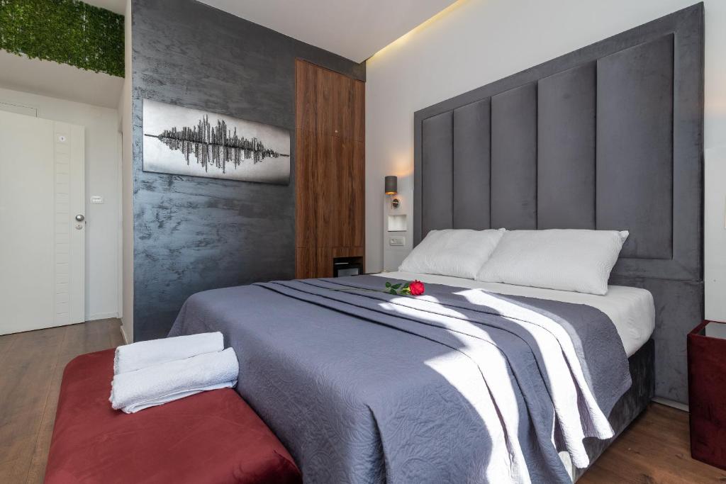 a bedroom with a large bed with a large headboard at Antares Luxury Rooms 2 in Split