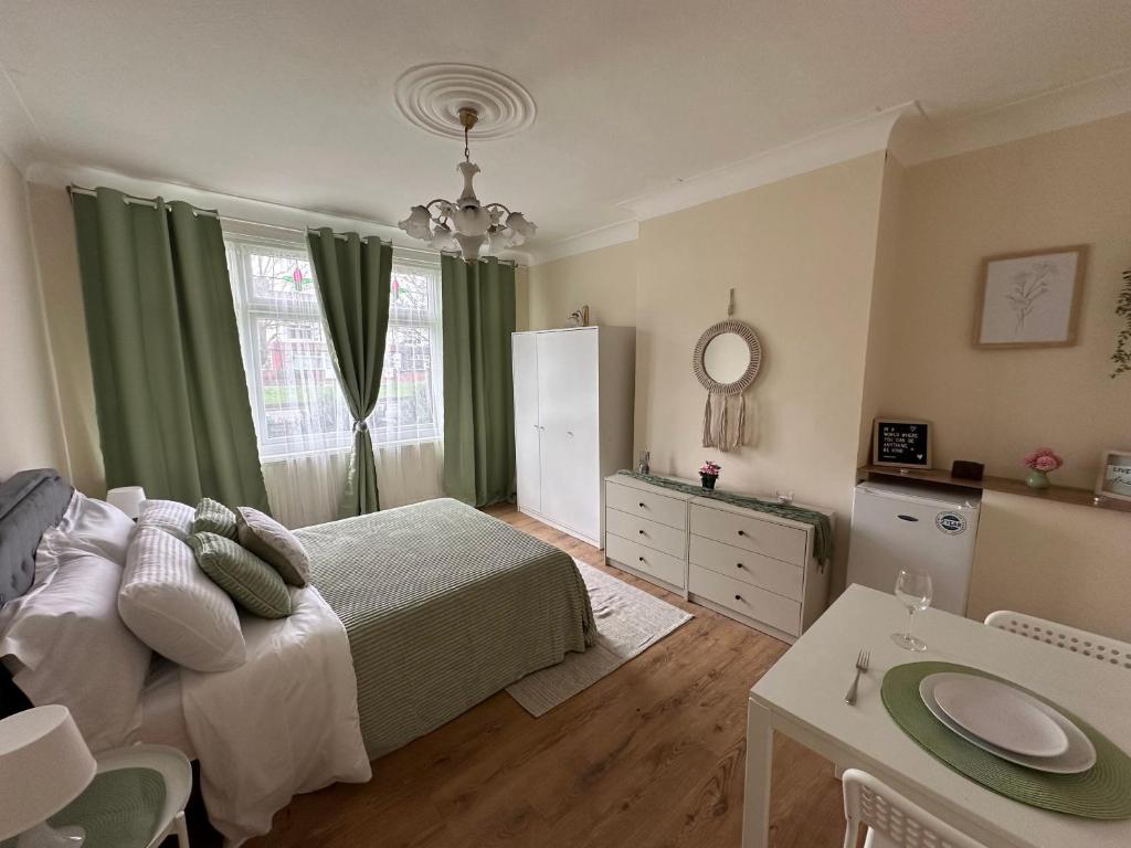 a bedroom with a bed and a table and a window at Downhills Way - North London - Rooms in London