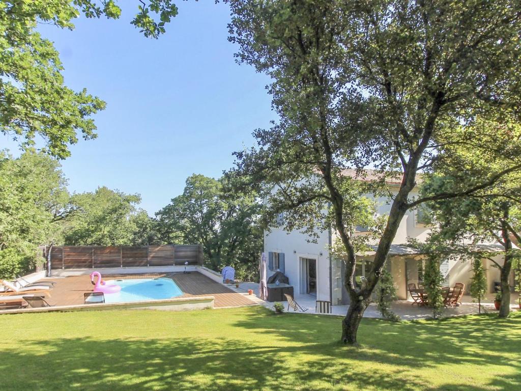 une maison avec une piscine dans une cour dans l'établissement Le Jardin des Chenes, à Eyragues