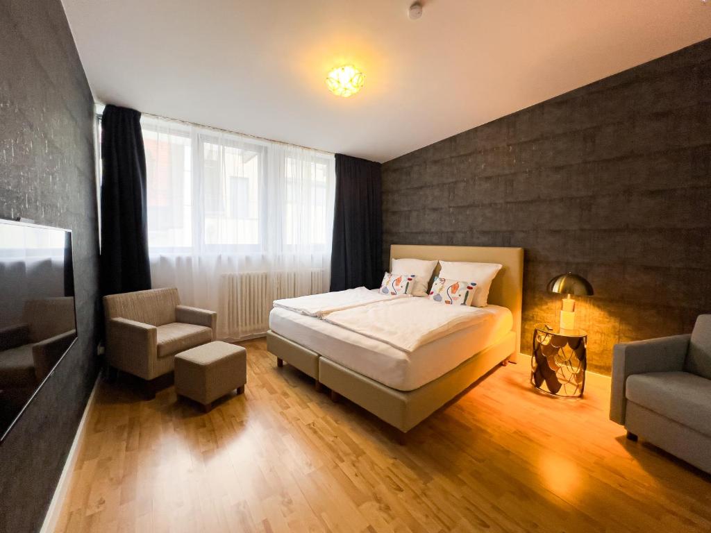 een slaapkamer met een bed, een bank en een stoel bij Exklusives Leipzig City Apartment Aurora in Leipzig