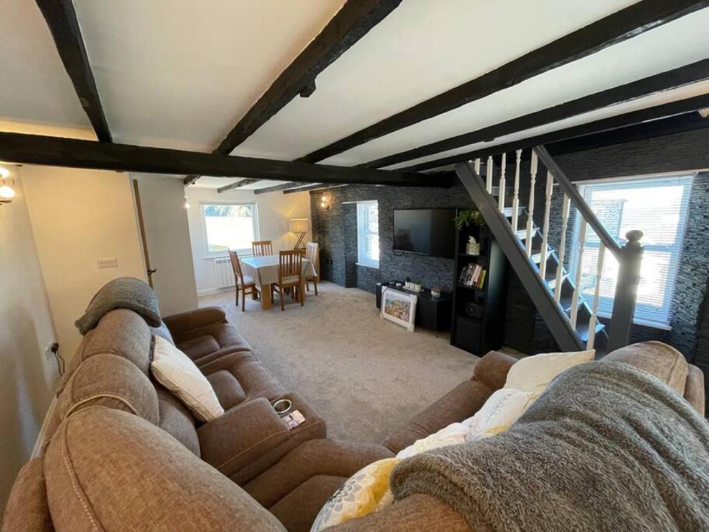 ポート・アイザックにあるAtlantic Cottage Port Isaac 2 bedroom with parkingのリビングルーム(ソファ、階段付)