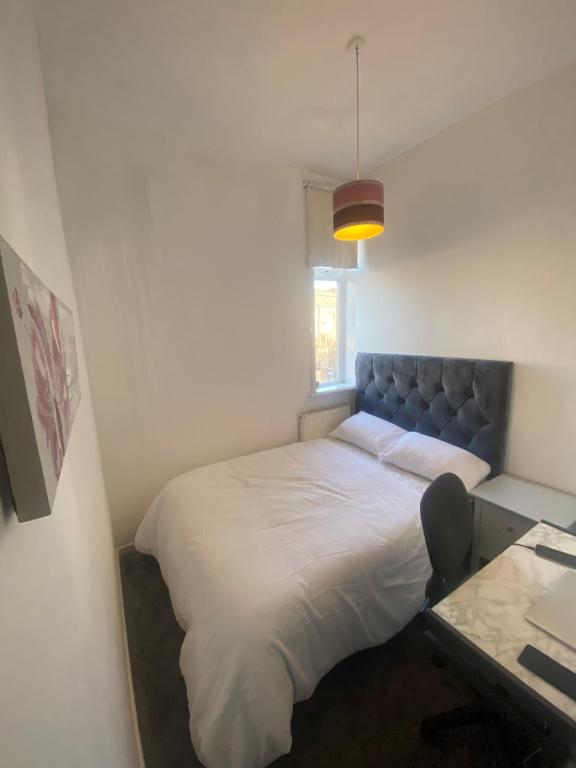 Bett in einem kleinen Zimmer mit einem Schreibtisch und einem Bett sidx sidx sidx in der Unterkunft Cozy One Room- Ideal for Getaways in Bury