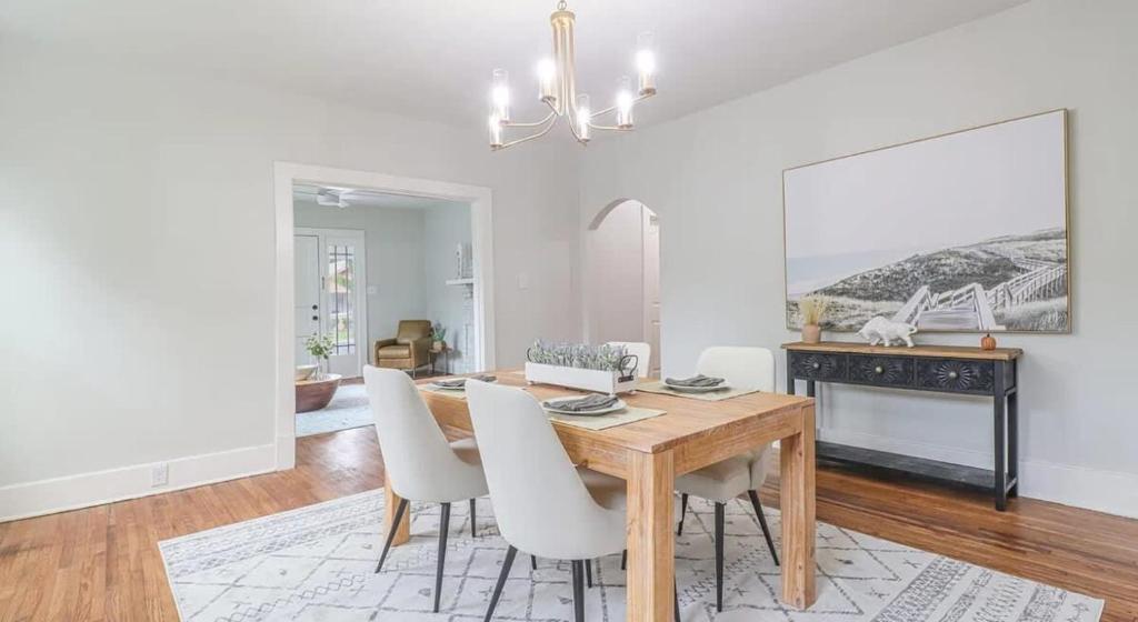 a dining room with a wooden table and white chairs at Modern Chateau Remodeled Home Close to Downtown in Mobile