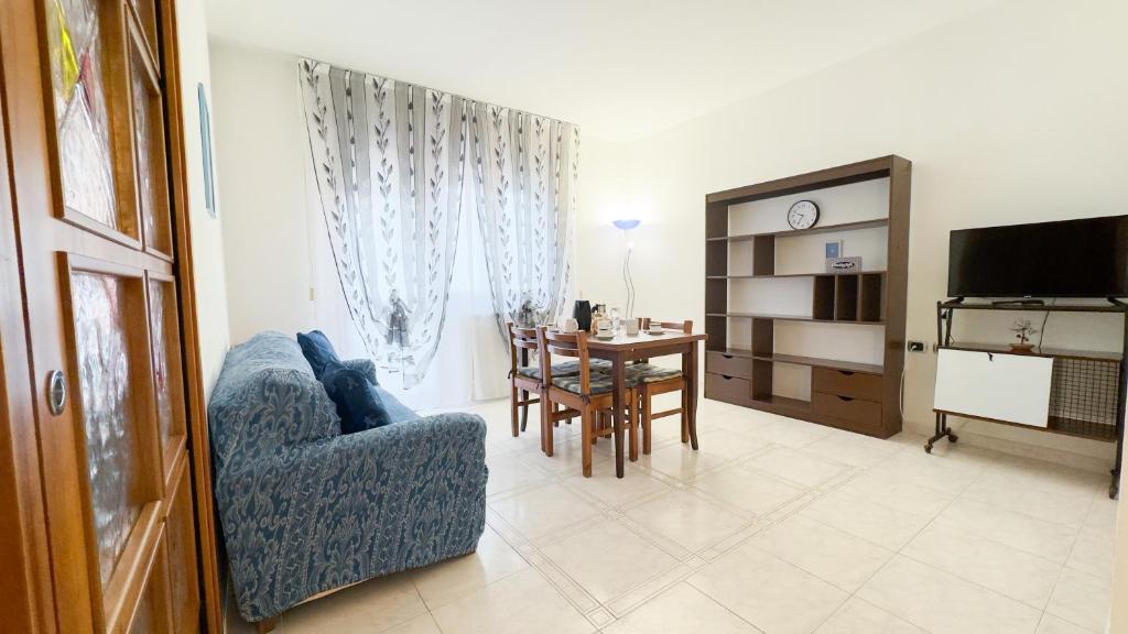 sala de estar con silla azul y mesa en Appartamento al Mare, en Chioggia