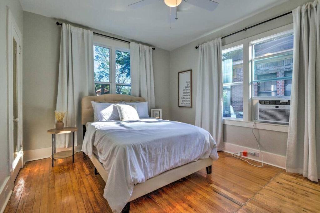 una camera da letto con un letto e due finestre di Modern Chateau Remodeled Home Close to Downtown a Mobile