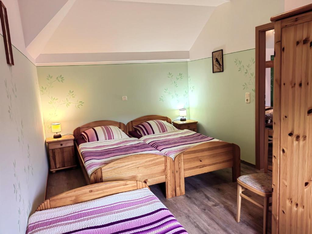 two beds in a room with green walls and wooden floors at Pension Claudia Güldenpfennig in Tangermünde