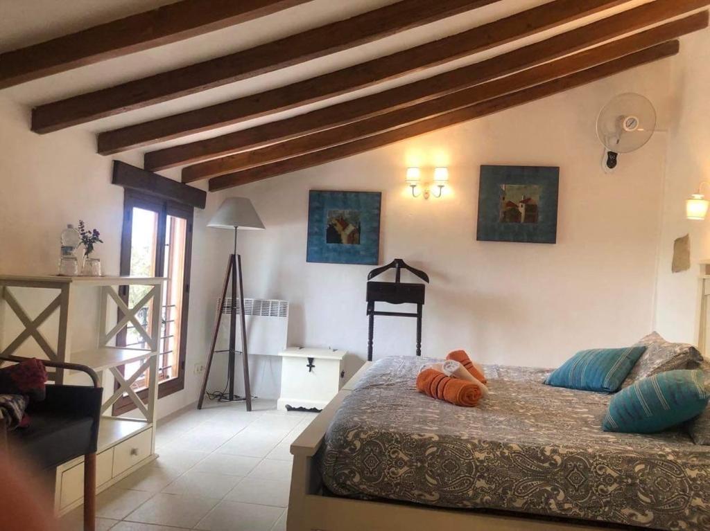sypialnia z łóżkiem w pokoju z drewnianymi belkami stropowymi w obiekcie Finca amorosa w mieście Villanueva de la Concepción