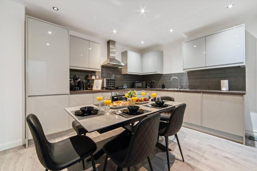 a kitchen with a table and chairs in a kitchen at Luxury Unit Sleeps 5 Ensuite 2 bath Games FREE WI-FI LEICESTER CITY CENTRE in Leicester