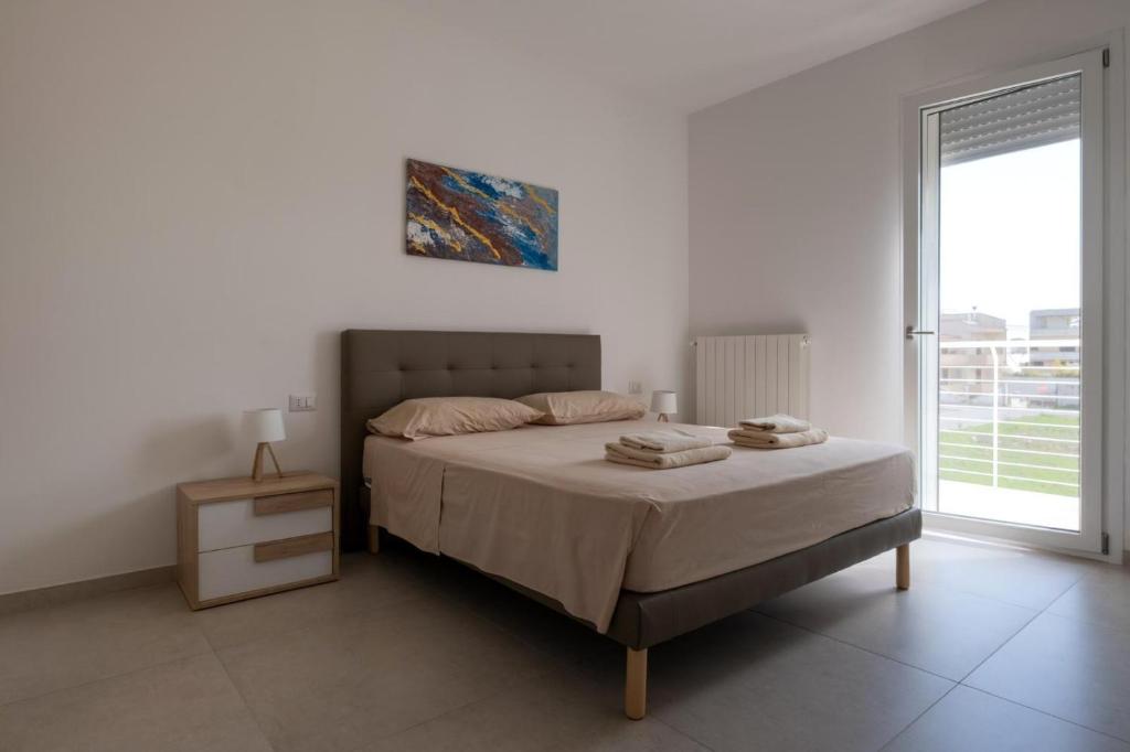 biała sypialnia z łóżkiem i oknem w obiekcie Casa Matilde w mieście Leverano