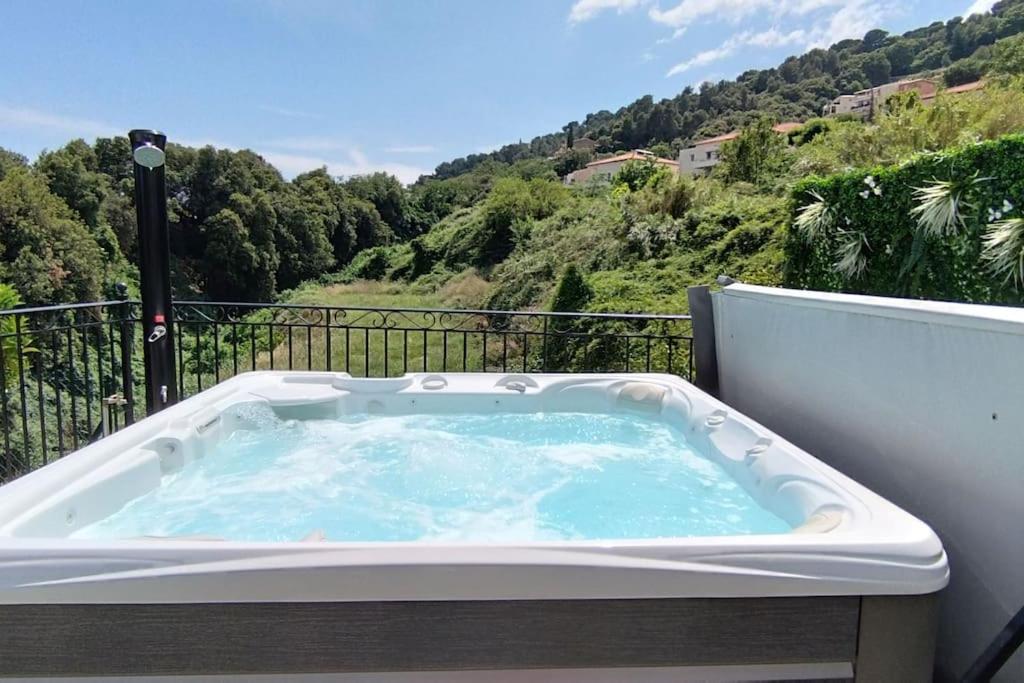 サン・ローラン・デュ・ヴァールにある2p bas de Villa avec Jacuzzi privatif proche de Niceの眺めの良いバルコニーにジャグジータブが備わります。