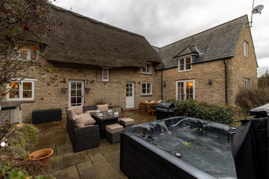 a garden with a hot tub in front of a building at Bird's Cottage in Kettering