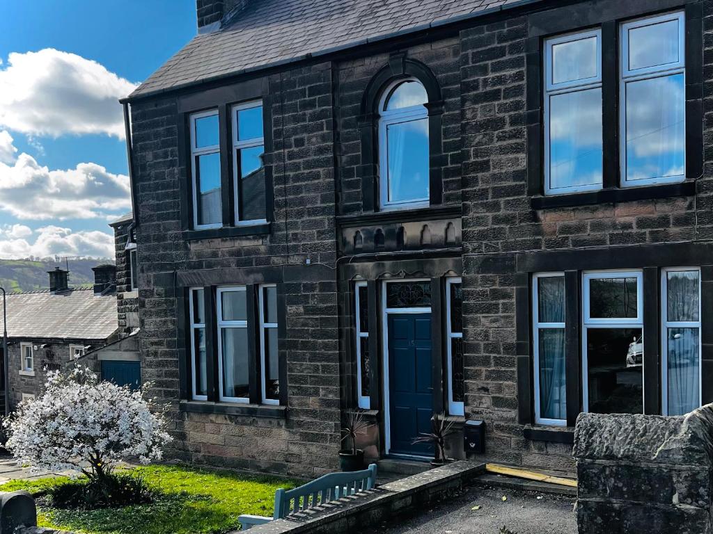 a brick house with a blue door and windows at Sherwood House in Matlock