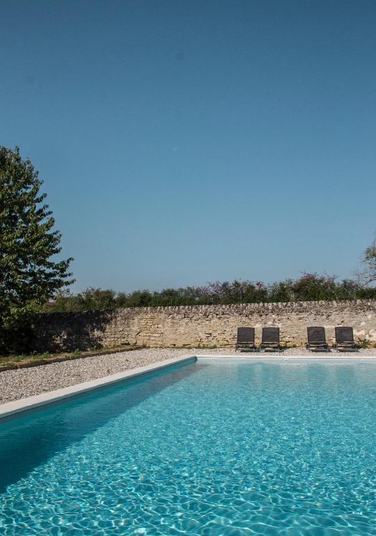 - une piscine avec 2 chaises et un peu d'eau dans l'établissement Grande maison de caractère avec Piscine, à Volesvres