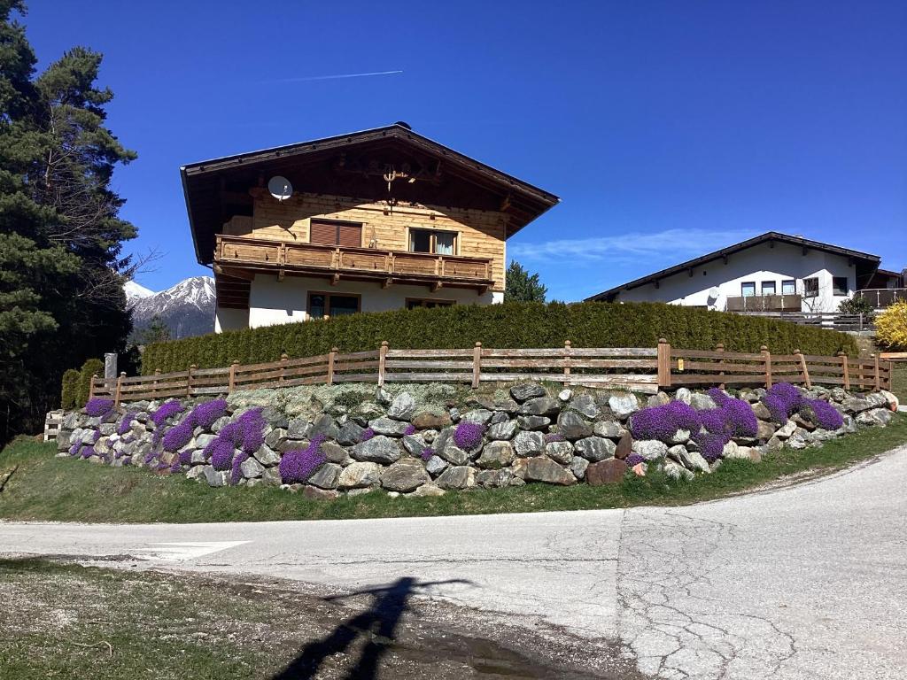 a house with a fence and purple flowers in front of it at Haus Wildspitz in Neustift im Stubaital