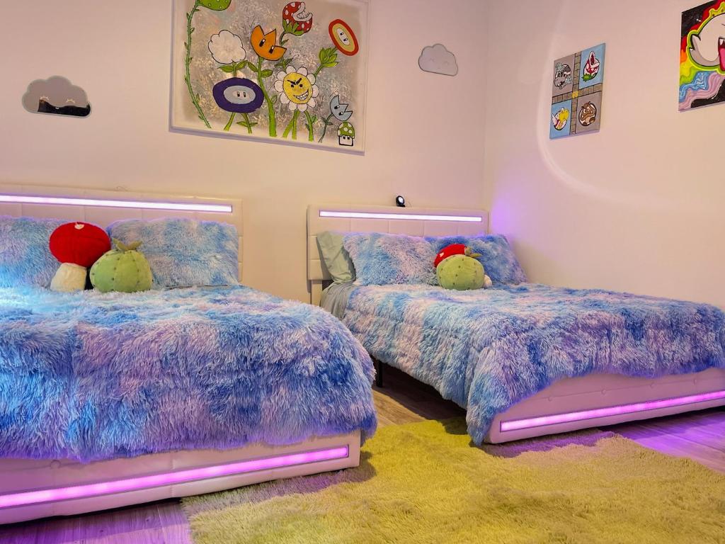 1 dormitorio con 2 camas con animales de peluche en The Neon Nest: Retro Chic 4BR Home in Cooper Young, en Memphis
