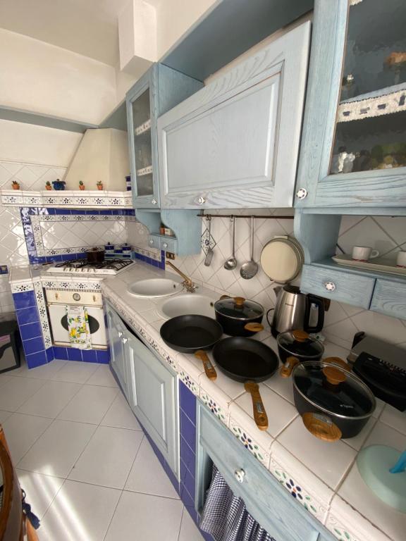 サンタニェッロにあるAmarea holiday home Sorrentoのキッチン(青と白のキャビネット、カウンター付)