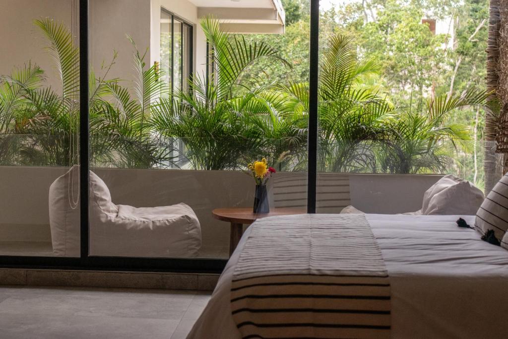 een slaapkamer met een bed en een groot raam bij Xamira Tulum Studios in Tulum