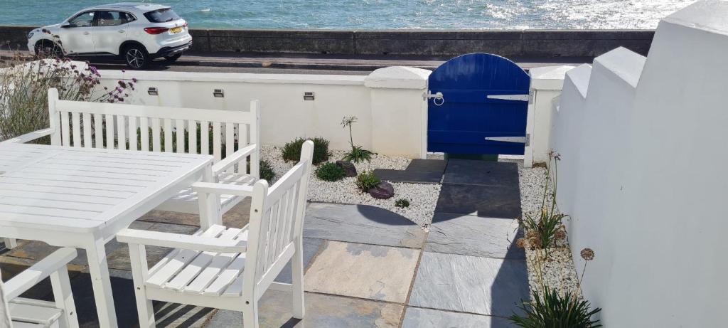 a patio with a table and chairs and a blue door at 4 bedroom house opposite the sea in Kent