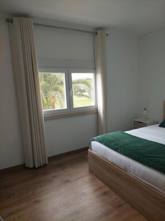 ein Schlafzimmer mit einem Bett und einem großen Fenster in der Unterkunft Quinta das Laranjeiras in Marinhais