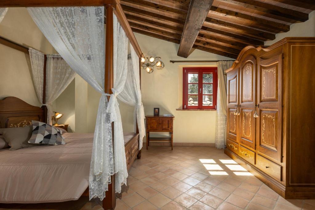 een slaapkamer met een hemelbed en een raam bij Borgo Mommialla Casa Alessandra in Gambassi Terme