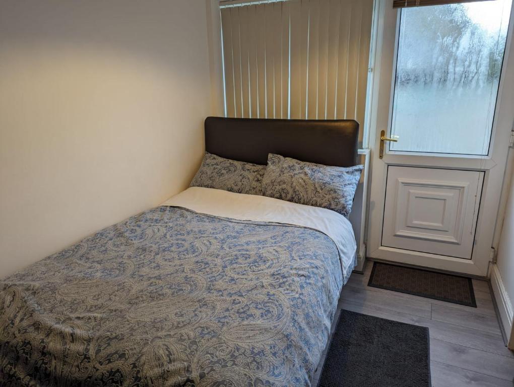 a small bedroom with a bed and a window at House in Leeds