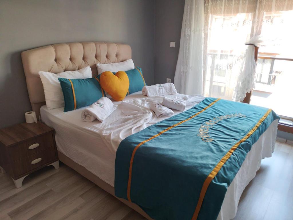 ein Schlafzimmer mit einem großen Bett mit einem Herzkissen in der Unterkunft Güven Rezidans in Buca