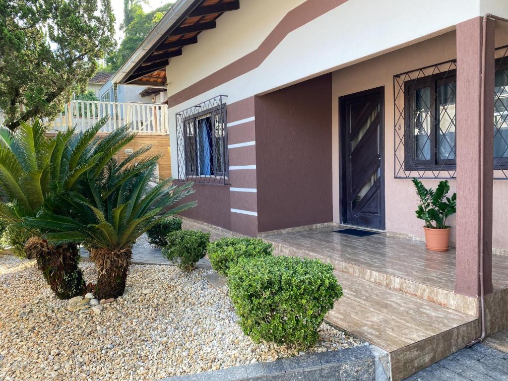 une maison avec des plantes devant elle dans l'établissement Pousada Paisagem, à Jaraguá do Sul