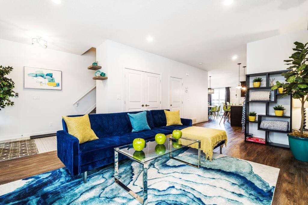 sala de estar con sofá azul y mesa en Vibrant Modern Oasis - Long Stays - Netflix - Wi-Fi en Edmonton